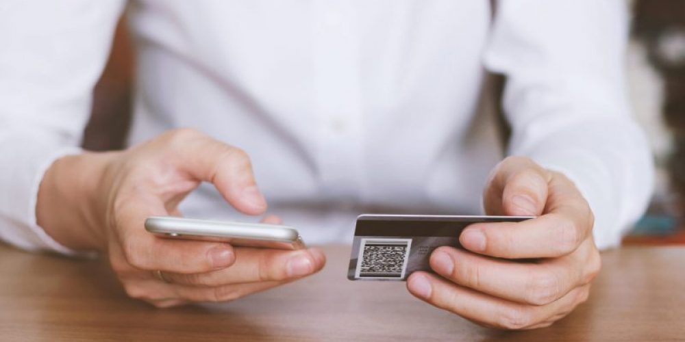 woman hands holding credit card and using smart phone for online shopping